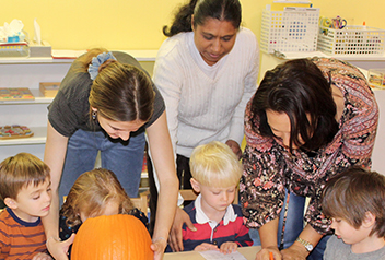  teachers with children and pumpkin