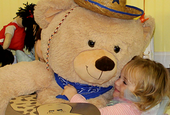little girl hugging a stuffed bear