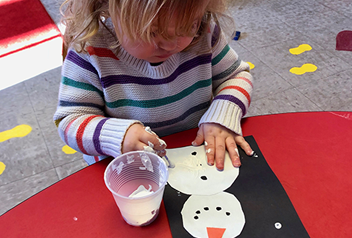 little girl painting a snowman