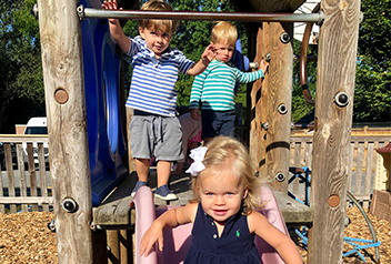 Young children playing outside on the slide